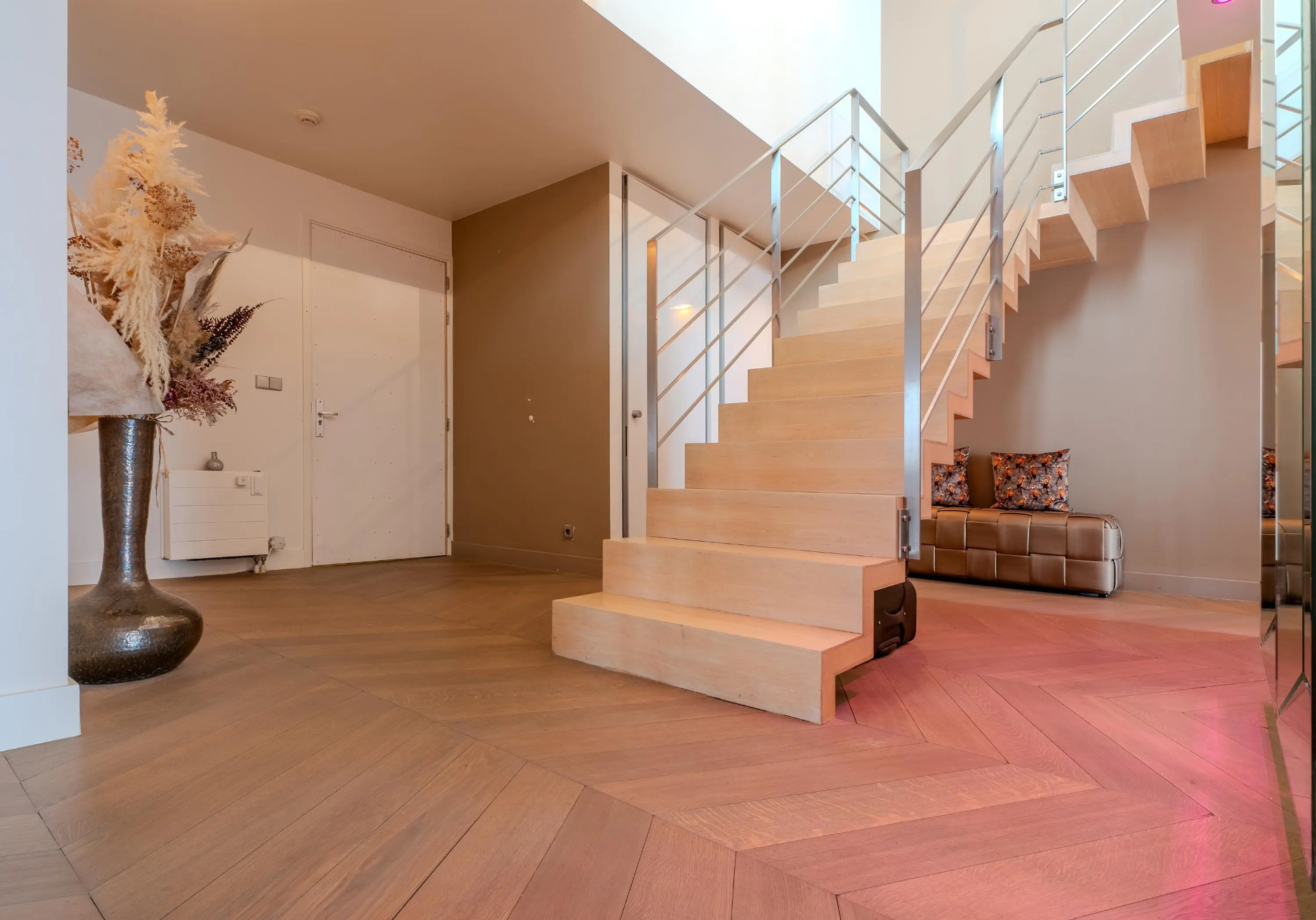 Double-height penthouse entrance with floating staircase
