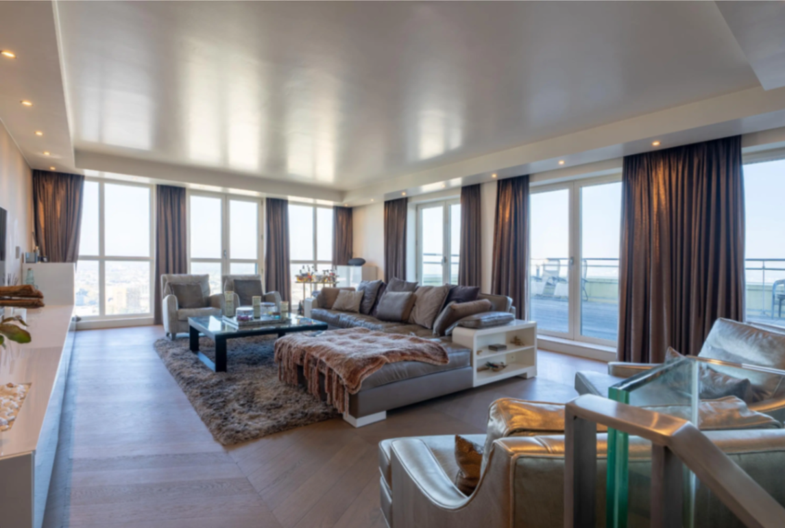 Penthouse living room with wraparound windows and terrace access